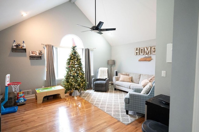 living room featuring hardwood / wood-style flooring, high vaulted ceiling, and ceiling fan