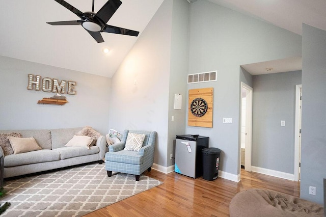 living room with hardwood / wood-style flooring, high vaulted ceiling, and ceiling fan