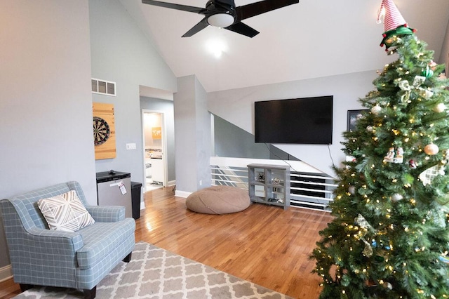 living room with hardwood / wood-style floors, high vaulted ceiling, and ceiling fan