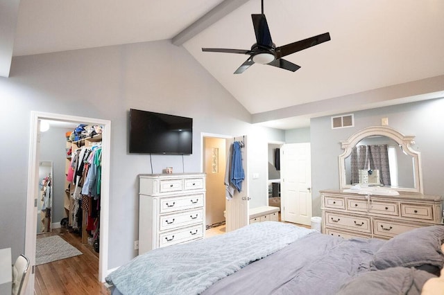 bedroom with a spacious closet, high vaulted ceiling, a closet, beamed ceiling, and light hardwood / wood-style floors