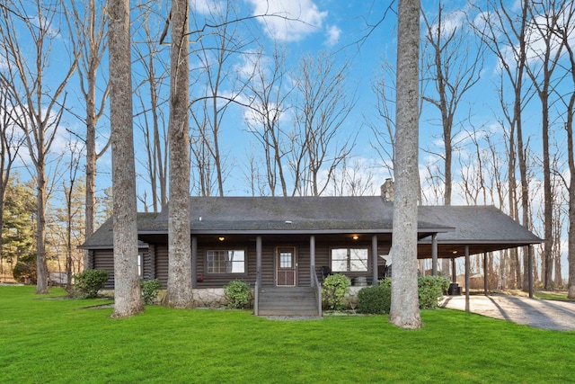 rear view of property with a lawn and a carport