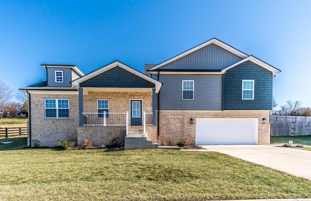 craftsman-style house featuring a front yard, concrete driveway, brick siding, and fence