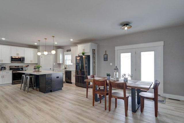 dining room featuring light wood-type flooring, baseboards, and recessed lighting