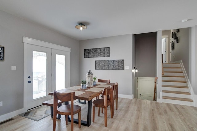 dining room with baseboards, light wood-style flooring, visible vents, and a healthy amount of sunlight