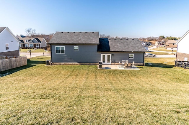 rear view of property with a patio area, a yard, fence, and french doors