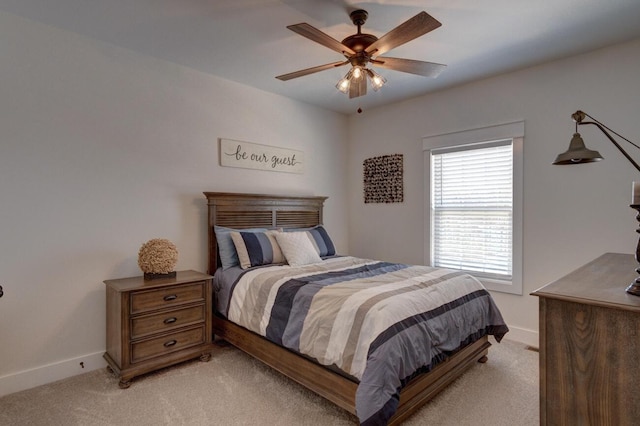 bedroom with light carpet, a ceiling fan, and baseboards