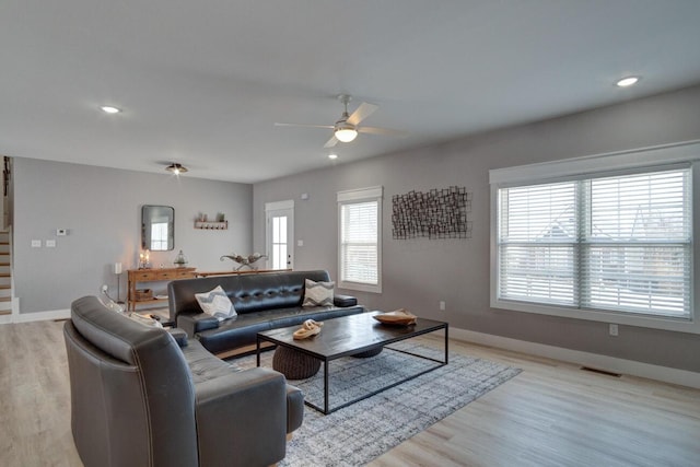 living room featuring light wood finished floors, recessed lighting, visible vents, baseboards, and stairs