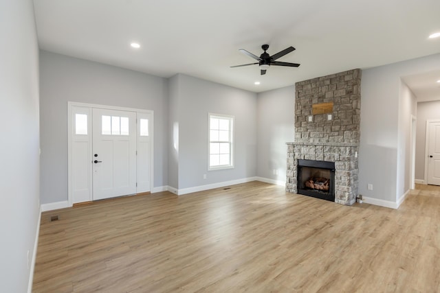 unfurnished living room with ceiling fan, a fireplace, and light hardwood / wood-style floors