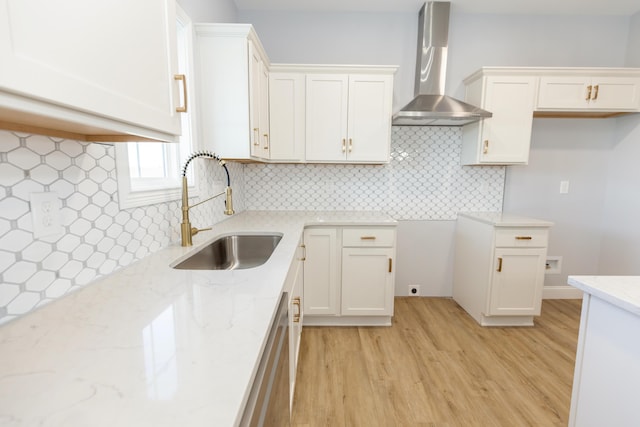 kitchen featuring white cabinetry, sink, decorative backsplash, and wall chimney exhaust hood