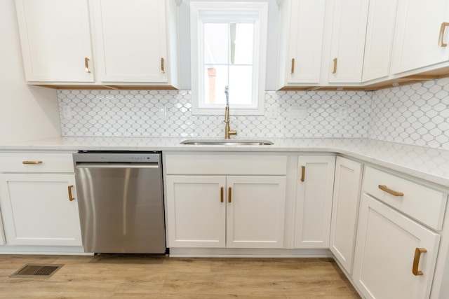 kitchen with dishwasher, light stone countertops, sink, and white cabinets