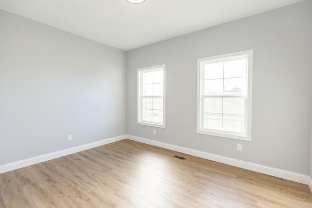 spare room featuring a wealth of natural light and light hardwood / wood-style flooring