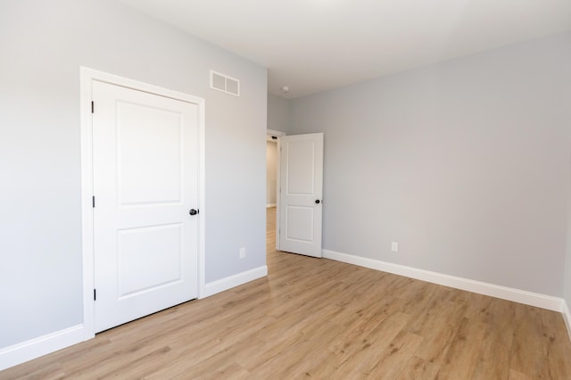 unfurnished bedroom with light hardwood / wood-style floors and a closet