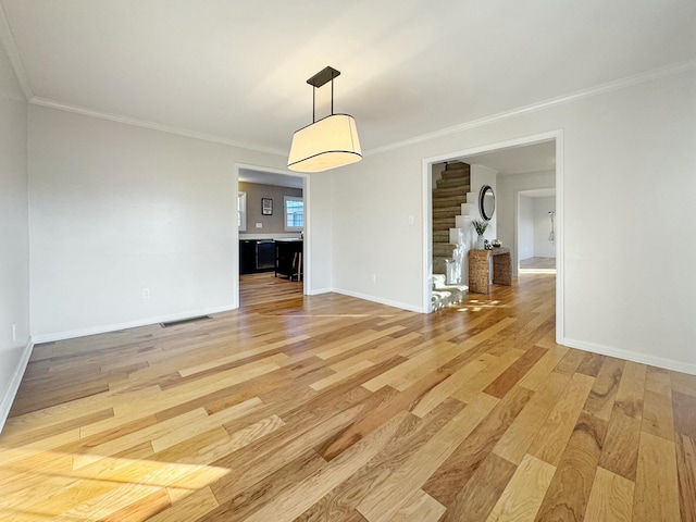 unfurnished dining area with hardwood / wood-style floors and crown molding