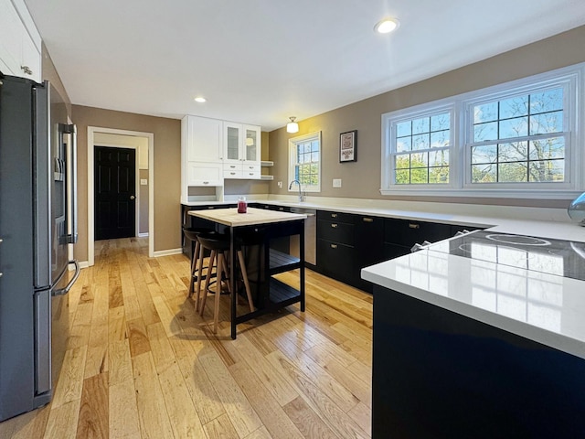 kitchen featuring light hardwood / wood-style flooring, white cabinets, a breakfast bar, and high end refrigerator