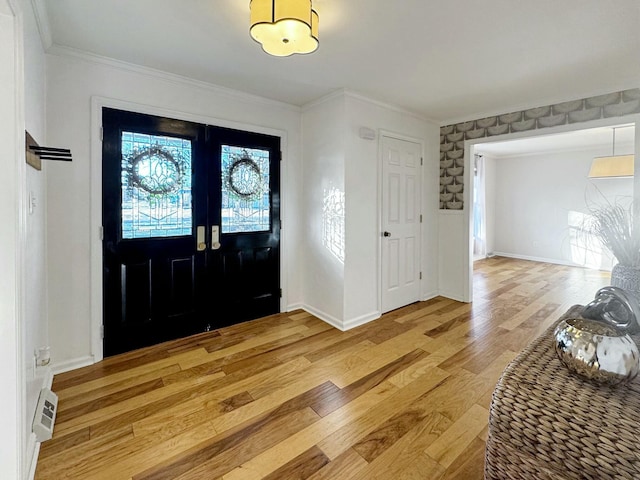 foyer featuring french doors, ornamental molding, and light hardwood / wood-style flooring