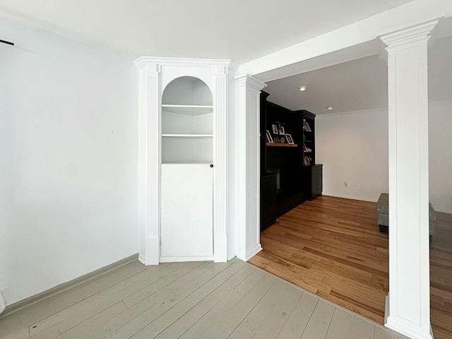 hallway with hardwood / wood-style flooring and decorative columns