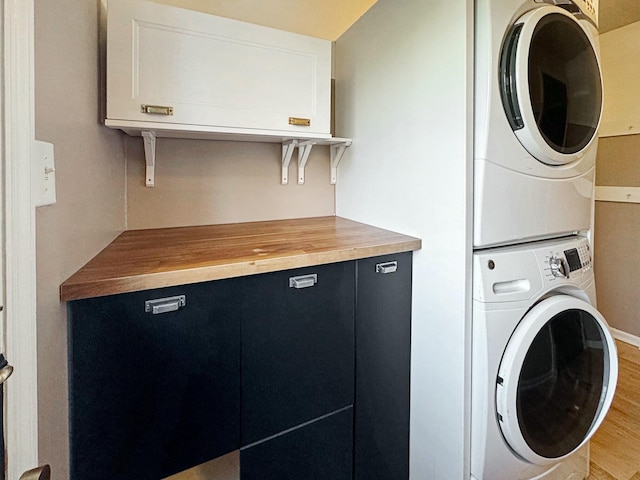 laundry area featuring stacked washer / drying machine