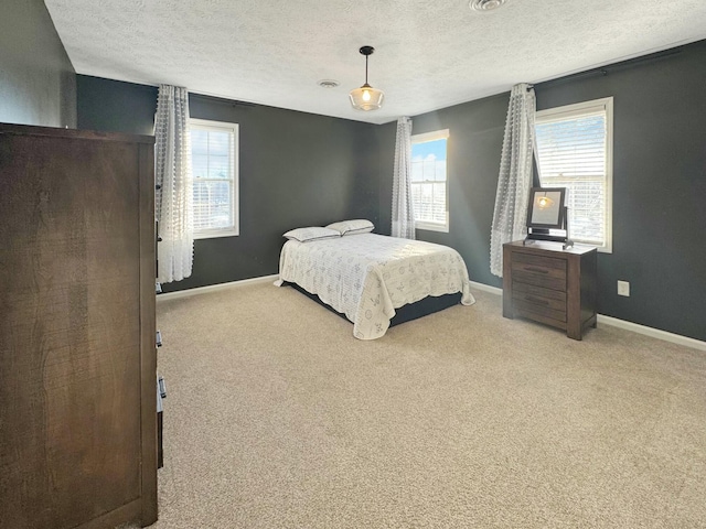 bedroom featuring a textured ceiling and light colored carpet