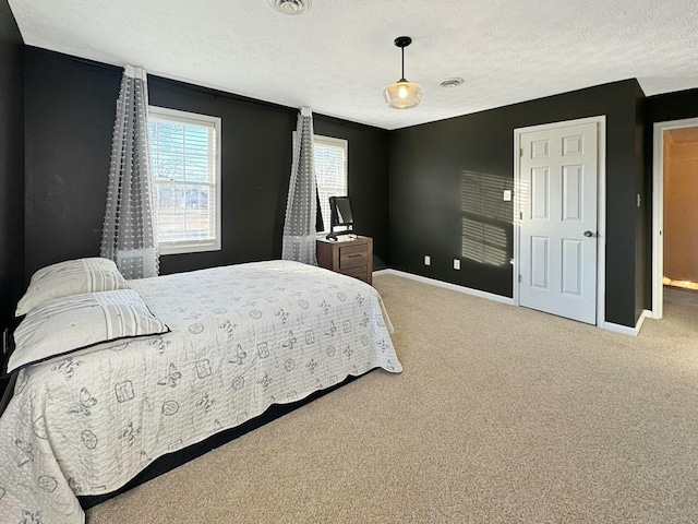 bedroom with carpet floors and a textured ceiling