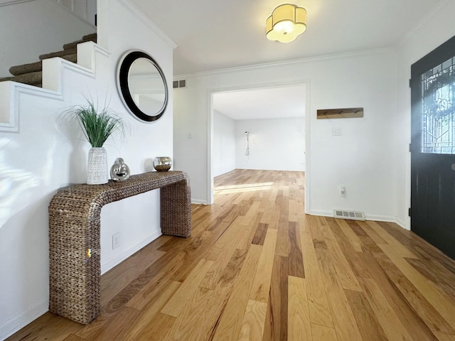 hallway featuring ornamental molding and light wood-type flooring