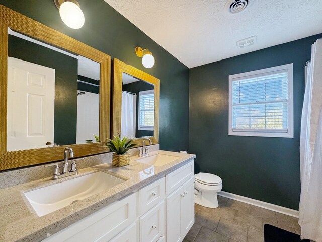 bathroom with a textured ceiling, toilet, and vanity