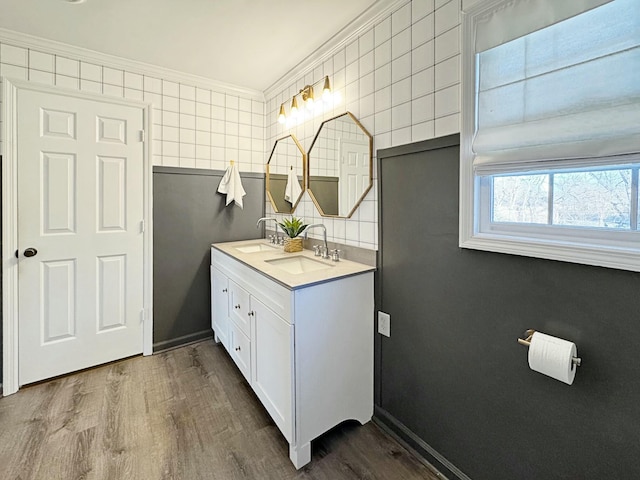 bathroom with tile walls, vanity, crown molding, and hardwood / wood-style floors