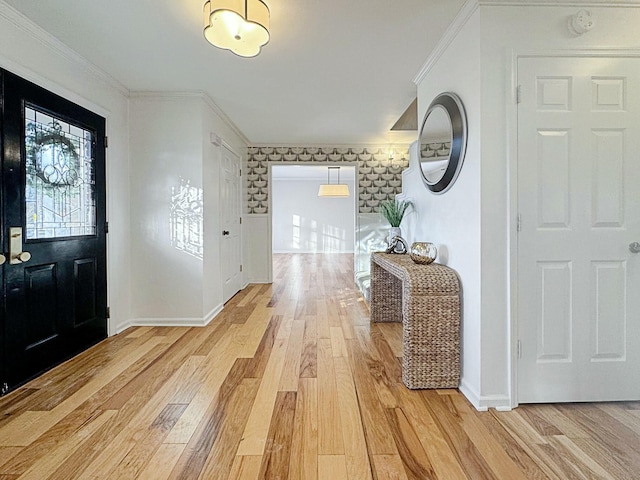 entryway with ornamental molding and light hardwood / wood-style flooring