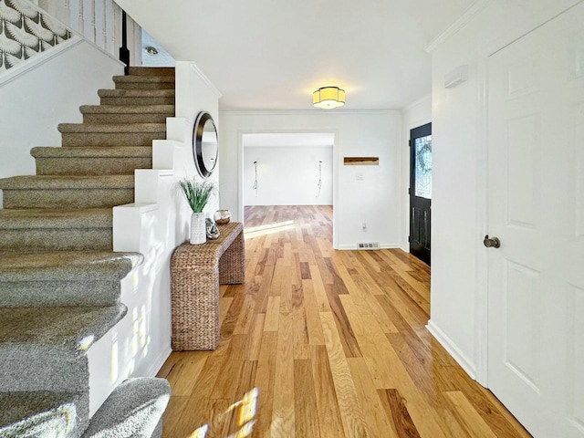 interior space featuring crown molding and light hardwood / wood-style flooring