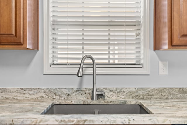 room details with light stone countertops and sink