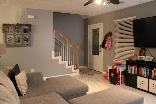 living room with ceiling fan and a textured ceiling