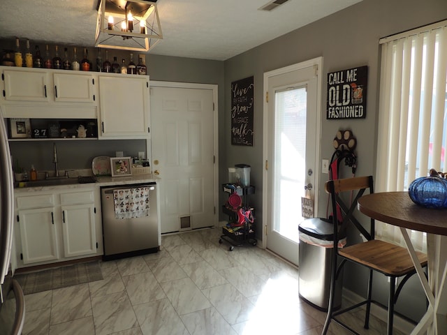 kitchen with white cabinetry, dishwasher, and sink