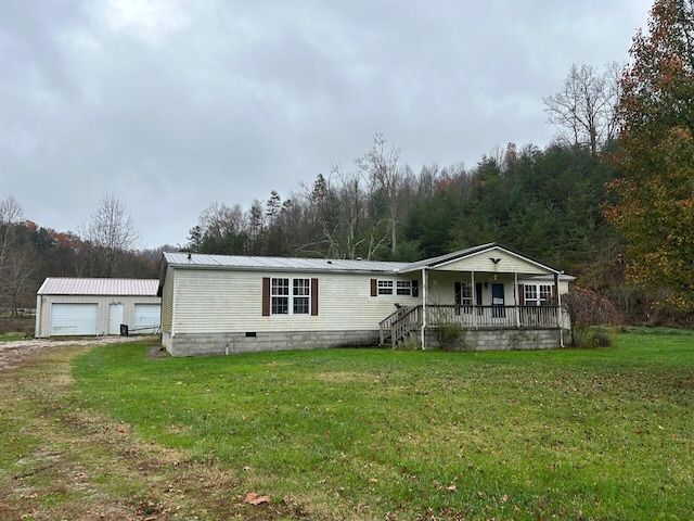 manufactured / mobile home with a porch, an outbuilding, a garage, and a front yard