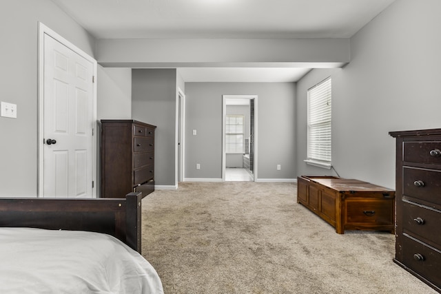 bedroom with carpet floors, baseboards, and connected bathroom