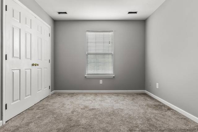 unfurnished bedroom featuring carpet floors, baseboards, and visible vents