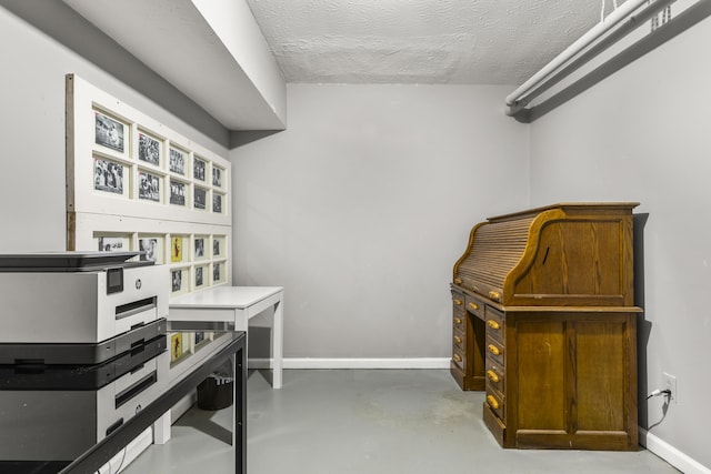 interior space with baseboards, concrete flooring, and a textured ceiling