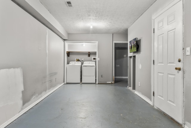 interior space featuring laundry area, a textured ceiling, baseboards, visible vents, and washer and clothes dryer