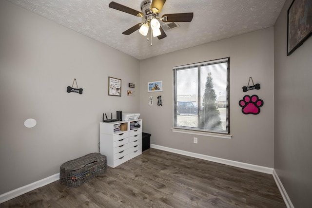 bedroom featuring ceiling fan, dark hardwood / wood-style floors, and a textured ceiling