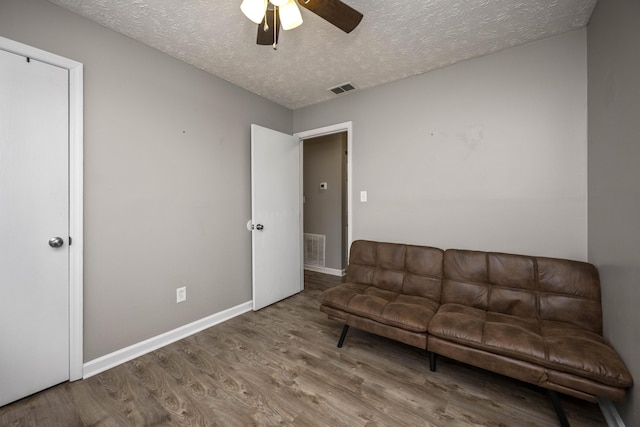 unfurnished living room featuring hardwood / wood-style floors, a textured ceiling, and ceiling fan