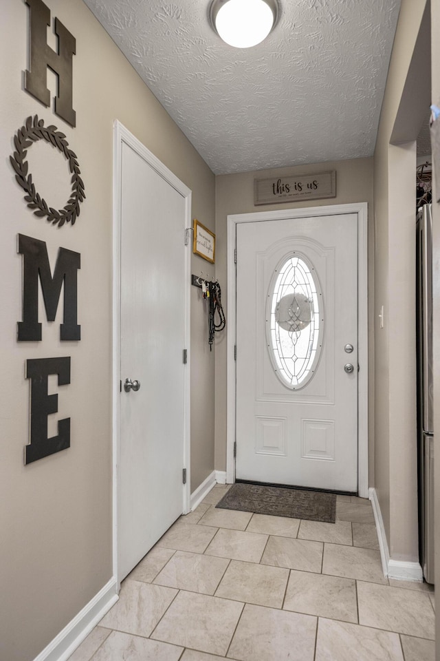 tiled foyer entrance featuring a textured ceiling