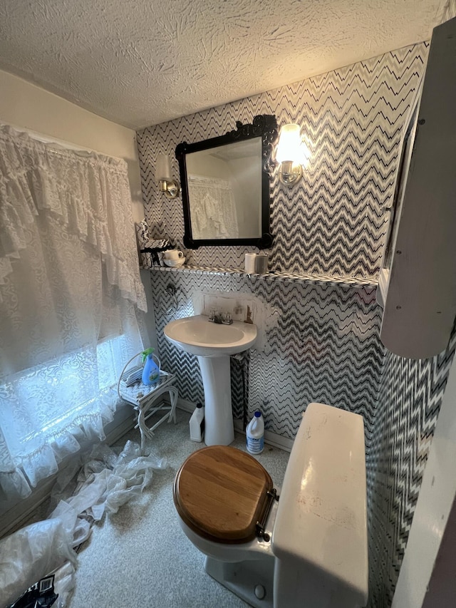 bathroom with toilet and a textured ceiling