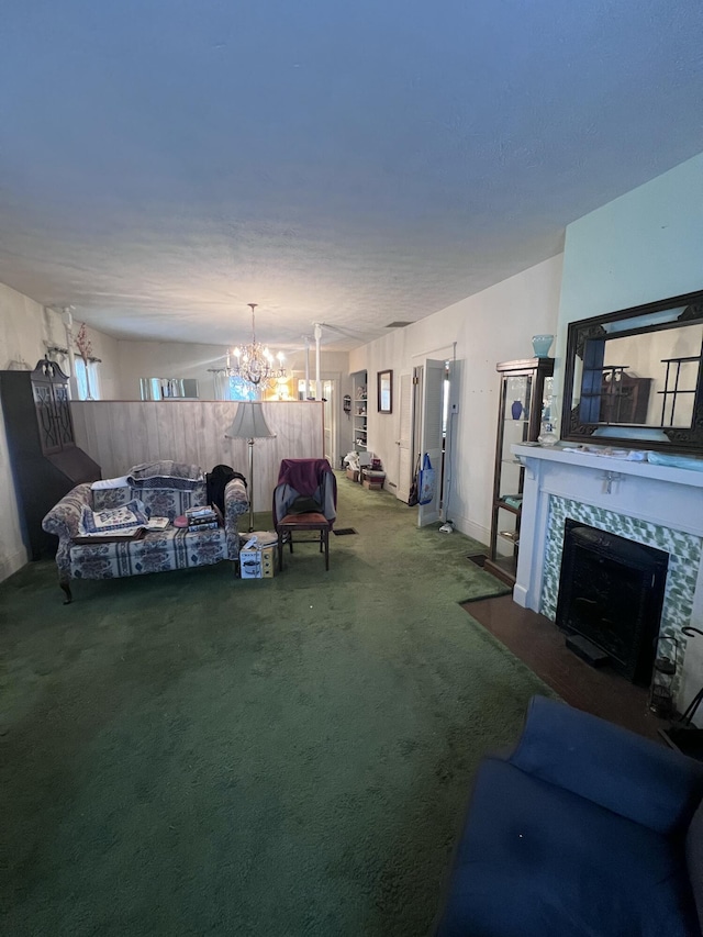 living room featuring an inviting chandelier, carpet floors, and a premium fireplace