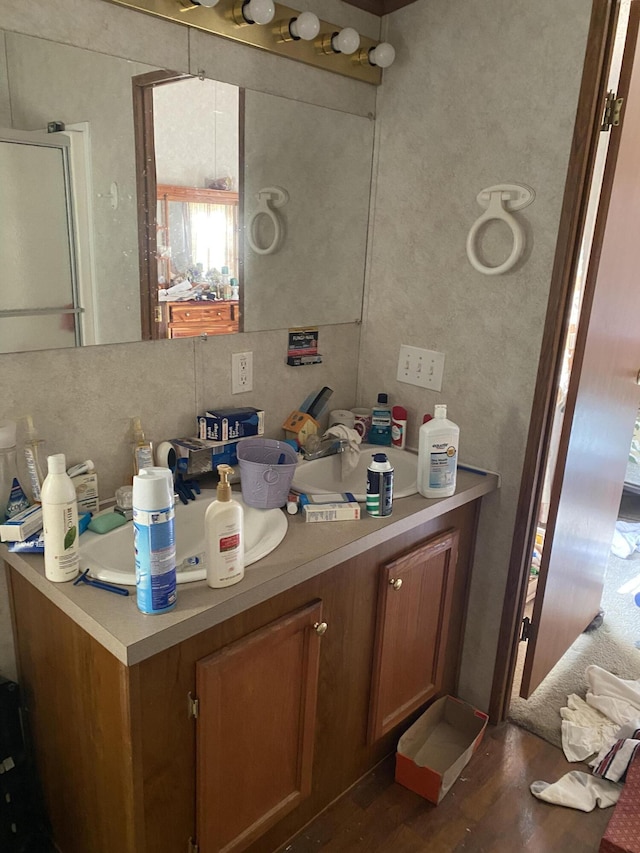 bathroom with hardwood / wood-style flooring, vanity, and decorative backsplash