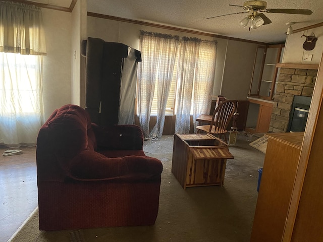 carpeted living room with a fireplace, crown molding, plenty of natural light, and a textured ceiling