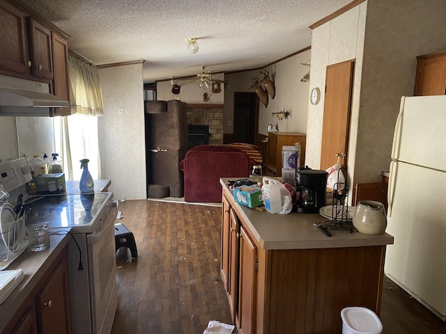 kitchen featuring lofted ceiling, a stone fireplace, a textured ceiling, dark hardwood / wood-style floors, and white appliances