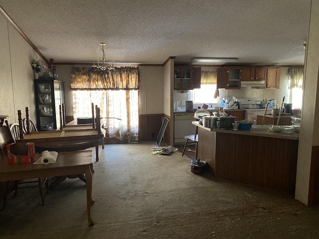 kitchen featuring crown molding, a textured ceiling, kitchen peninsula, white appliances, and carpet