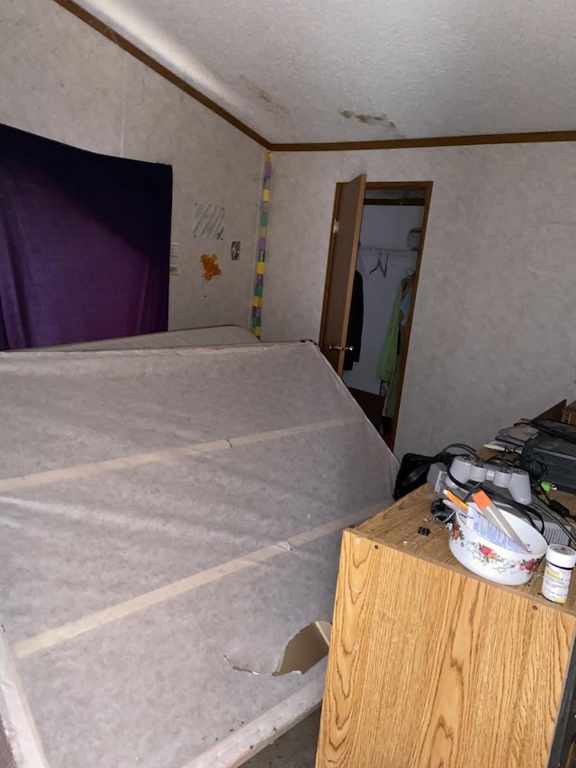 bedroom featuring crown molding, a textured ceiling, and a closet