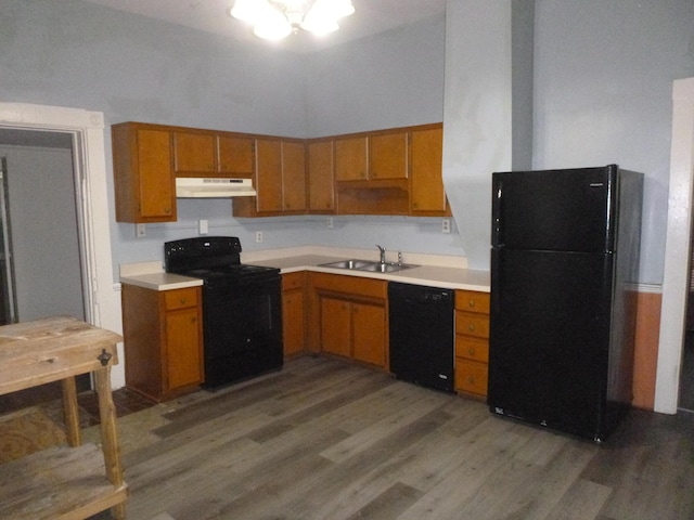 kitchen featuring a towering ceiling, sink, dark hardwood / wood-style floors, and black appliances