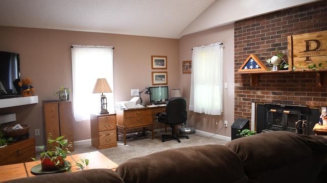 carpeted home office with vaulted ceiling and a brick fireplace