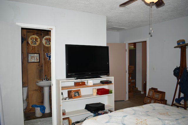 bedroom with sink, ceiling fan, a textured ceiling, and ensuite bathroom