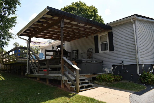 exterior space with a yard, a hot tub, and a deck